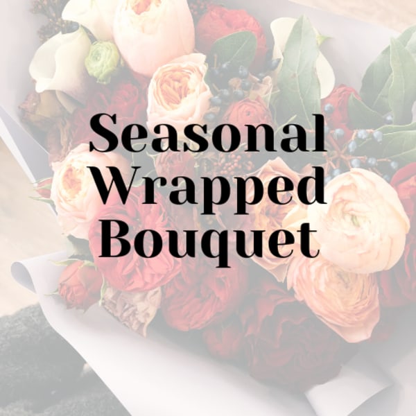 Wrapped bouquet of blush and red roses with greenery