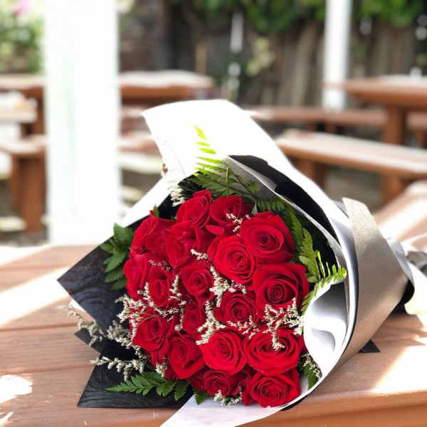 Bouquet of red roses wrapped in black and white paper