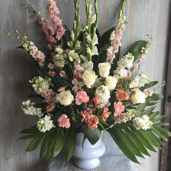 Tall floral arrangement in a white vase with pink and white blooms