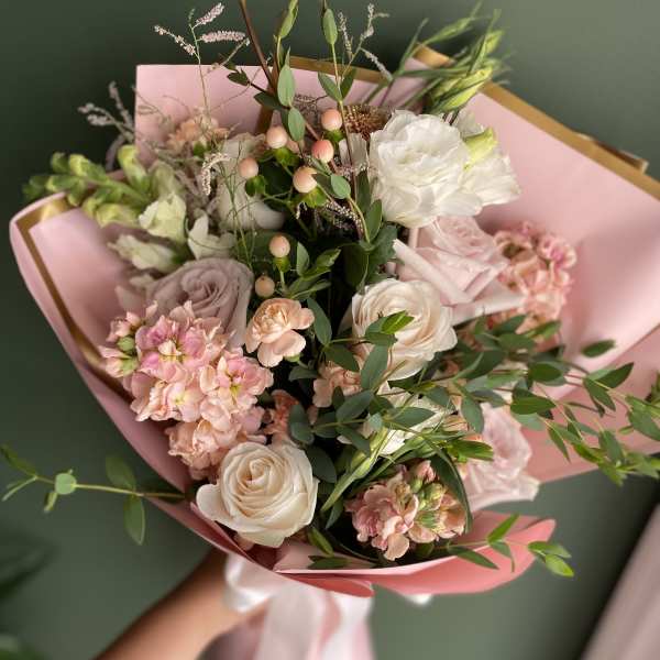 Pink and white bouquet with roses and carnations wrapped in pink paper