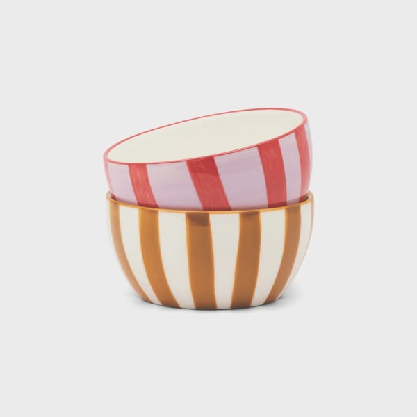 Two striped ceramic bowls stacked together on a white background