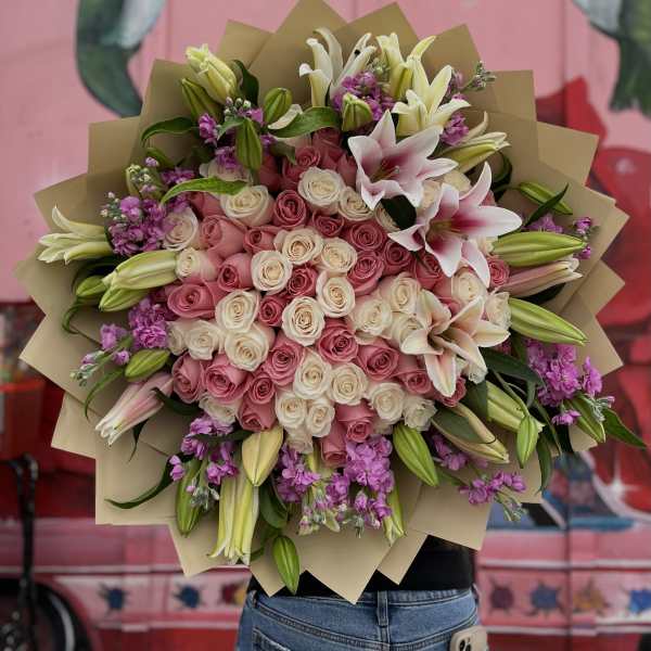 Large bouquet of pink and white roses with lilies and purple filler flowers