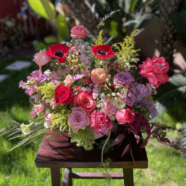Mixed pink and red flower arrangement with roses and anemones