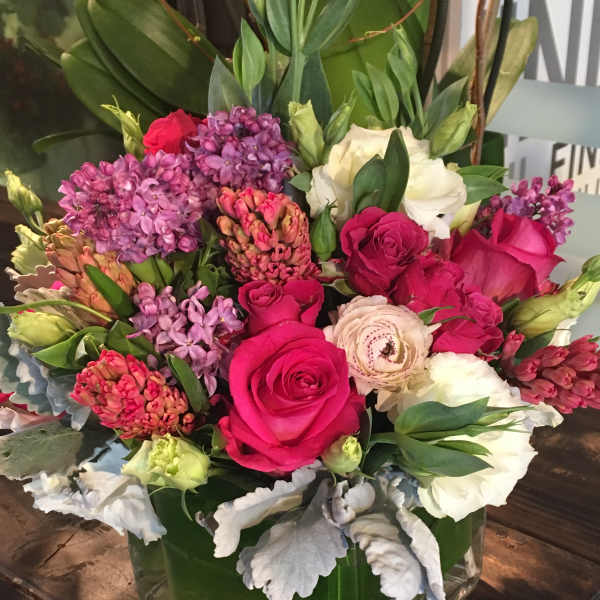 Bouquet of pink and white flowers in a square glass vase