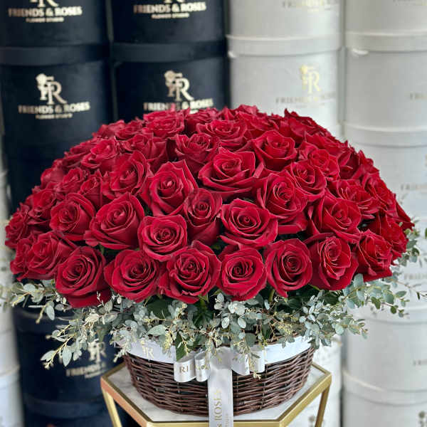 Large dome of red roses in a wicker basket with eucalyptus