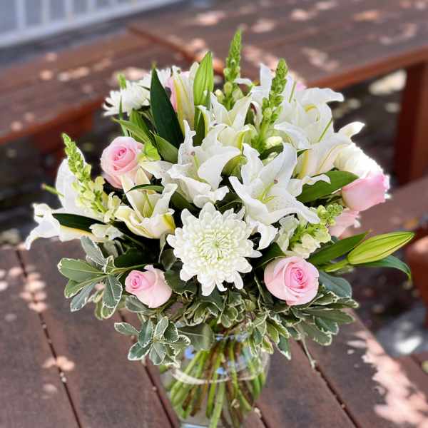 Pink roses and white lilies in a glass vase