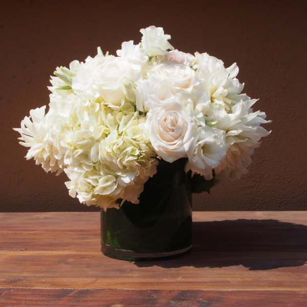 White floral arrangement in a dark glass vase