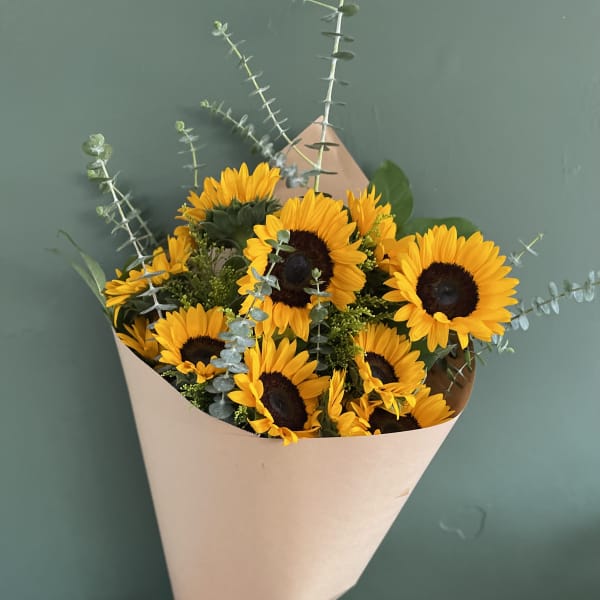 Bouquet of yellow sunflowers wrapped in beige paper