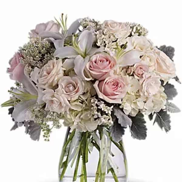 Bouquet of pale pink and white roses in a clear glass vase