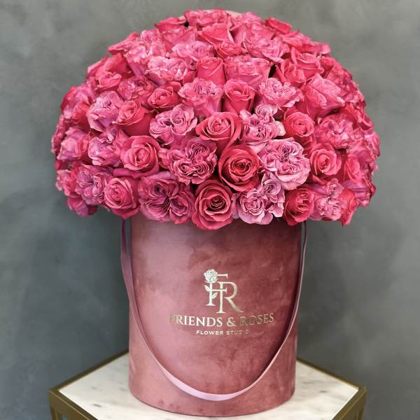 Large pink rose arrangement in a round velvet hatbox
