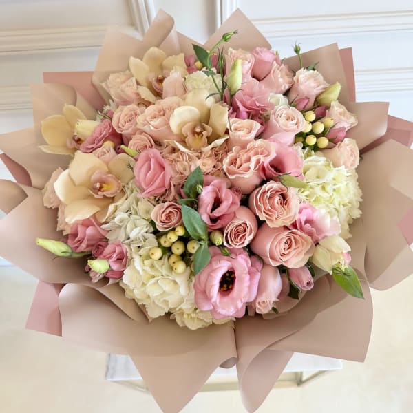 Bouquet of pink and cream flowers wrapped in blush paper