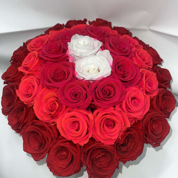 Round bouquet of red and white roses in a white box