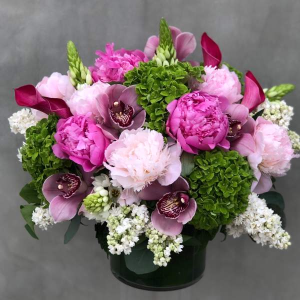Pink and white floral arrangement in a dark vase