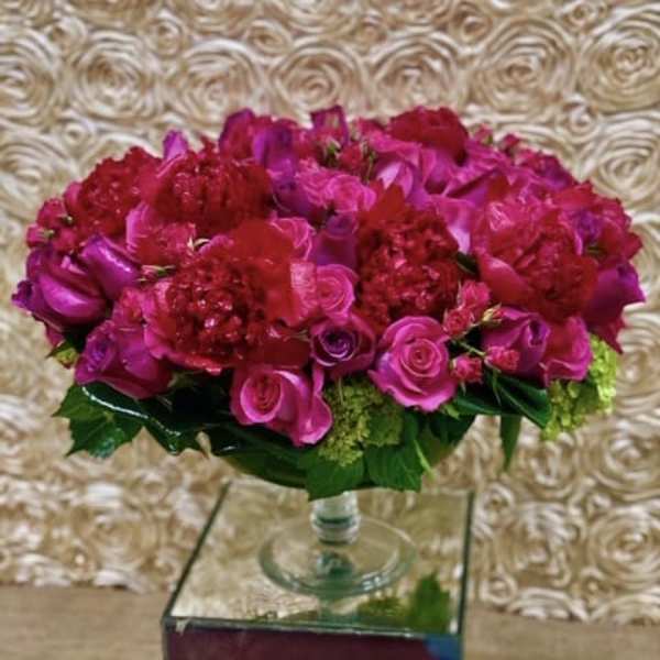 Pink and red rose arrangement in a clear glass vase