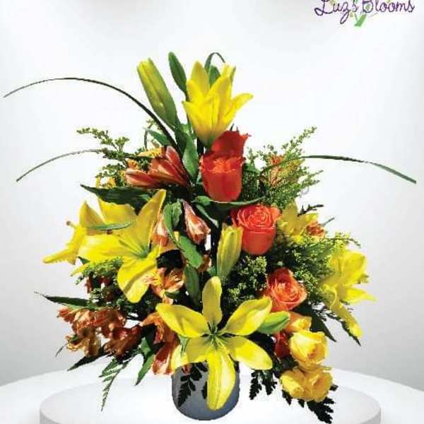 Bright bouquet of yellow lilies and orange roses in a vase