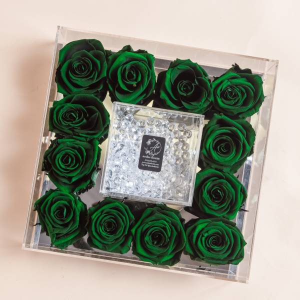 Green roses arranged in a clear square box with a crystal center