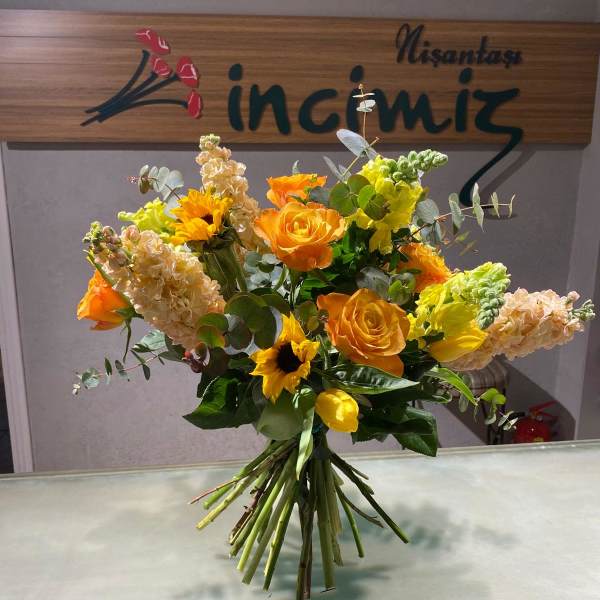 Bouquet of orange roses and yellow sunflowers with pale blooms