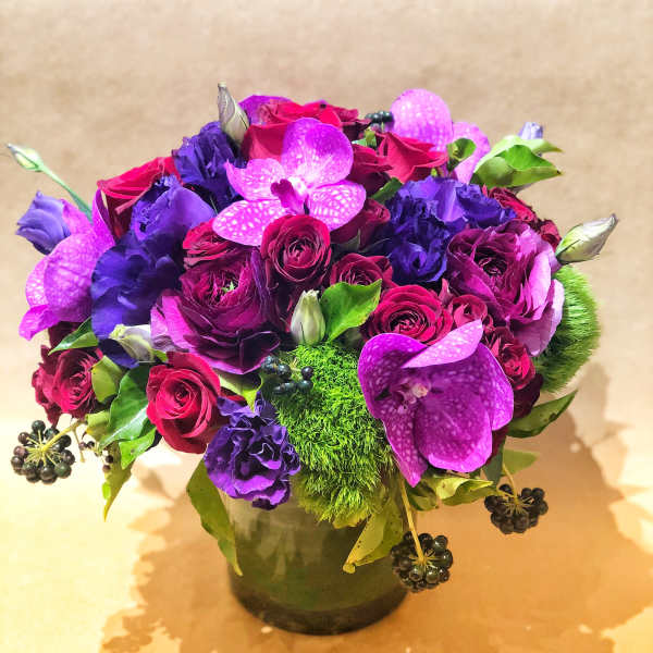 Purple and pink flower arrangement in a glass vase