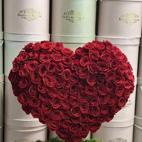 Heart-shaped arrangement of red roses on a stand