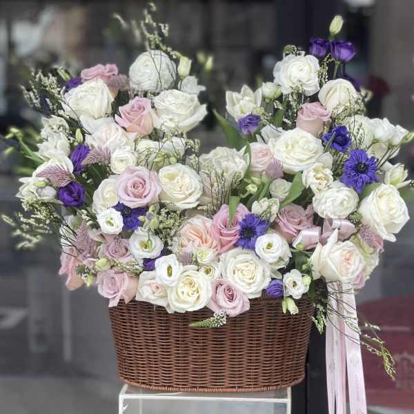 Basket arrangement of white, pink, and purple flowers