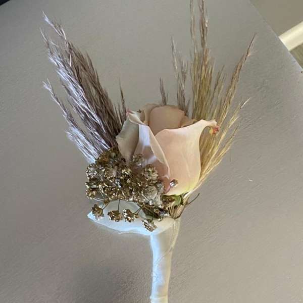 Boutonniere with a pale calla lily and dried grasses