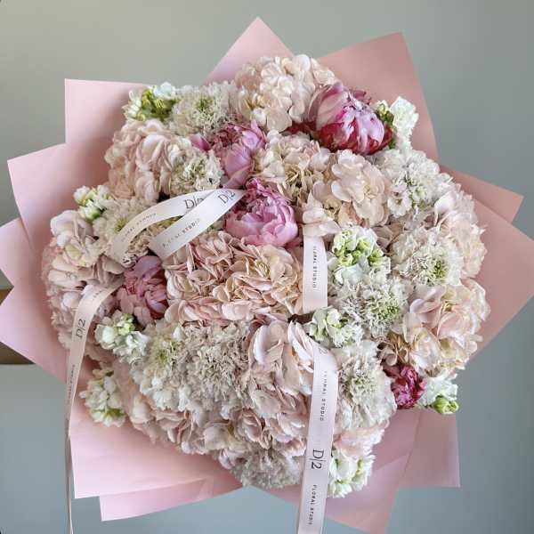 Large pastel bouquet of pink and white flowers wrapped in pink paper