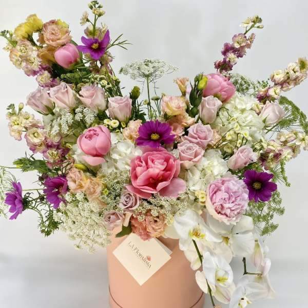 Mixed pink and white flower arrangement in a peach hat box