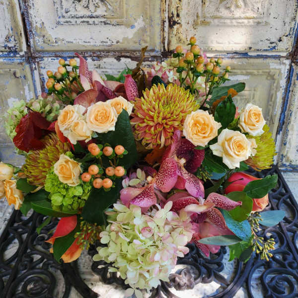 Mixed bouquet with peach roses, pink orchids, and green chrysanthemums