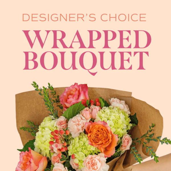 Wrapped bouquet of pink, peach, and green flowers in brown paper