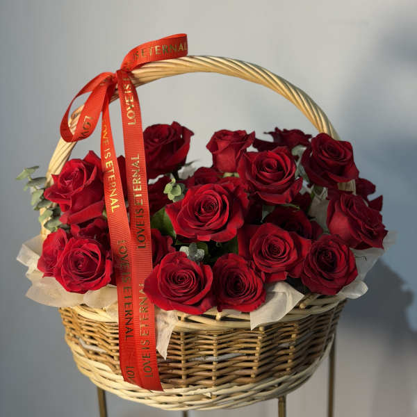 Basket of red roses with a red ribbon