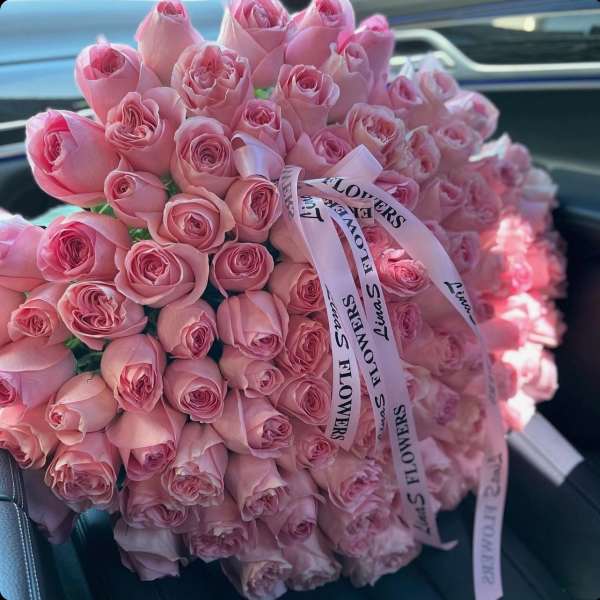 Large bouquet of pink roses tied with a printed ribbon