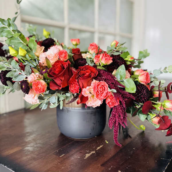 Mixed bouquet of red and pink roses in a gray vase