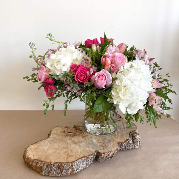 Pink and white flower arrangement in a clear glass vase