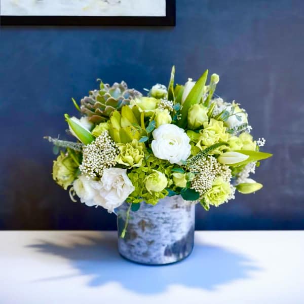 Green and white floral arrangement in a metal vase