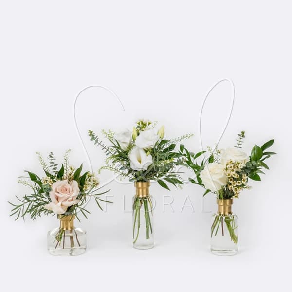 Three small floral arrangements in glass vases with gold collars