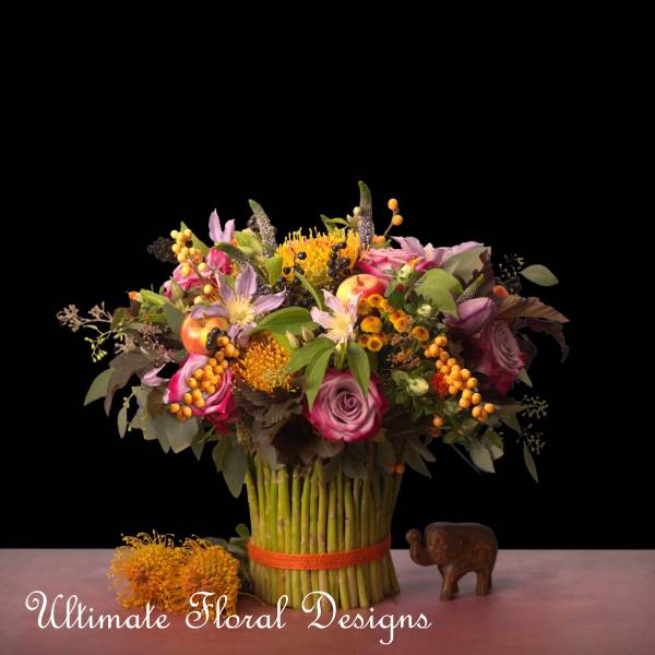 Mixed bouquet with pink roses and orange blooms in a wrapped stem bundle