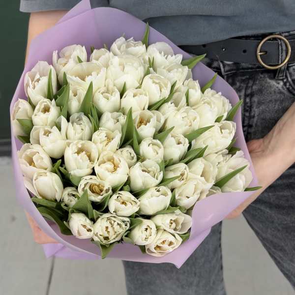 Bouquet of white tulips wrapped in lavender paper
