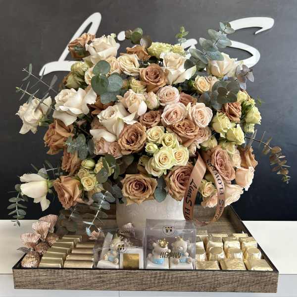 Large bouquet of cream and blush roses with eucalyptus in a white box, with chocolates below