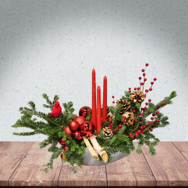 Holiday centerpiece with red candles, pinecones, and red ornaments
