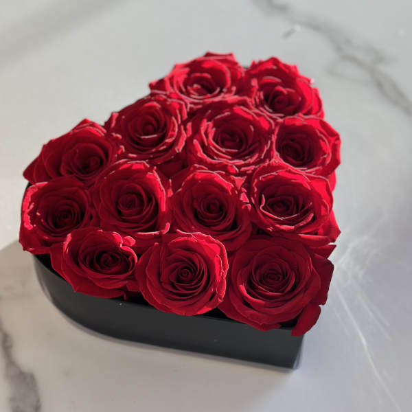 Red roses arranged in a black heart-shaped box