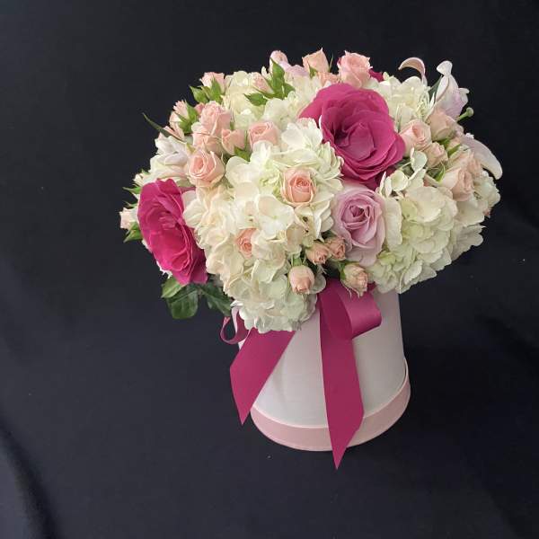 Pink and white rose bouquet in a white hat box with a magenta ribbon