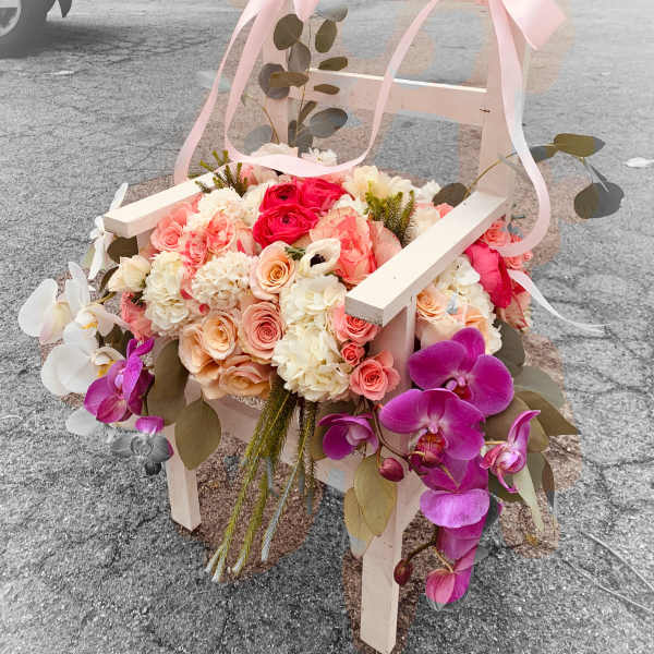 Flower-covered chair with pink ribbons and orchids