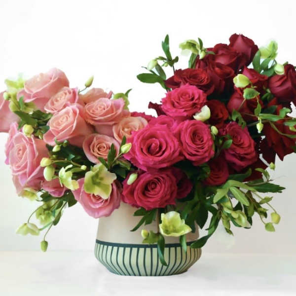 Pink and red rose arrangement in a striped vase