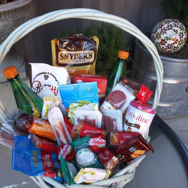 Gift basket filled with assorted snack packages and two bottles