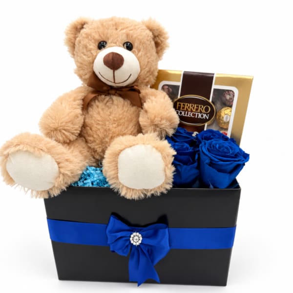 Teddy bear with blue roses and a chocolate box in a gift basket
