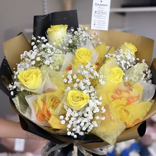 Bouquet of yellow roses with white baby's breath in gold and black wrap