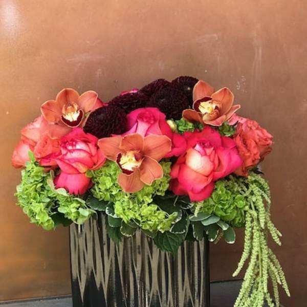 Pink roses and orchids in a black rectangular vase