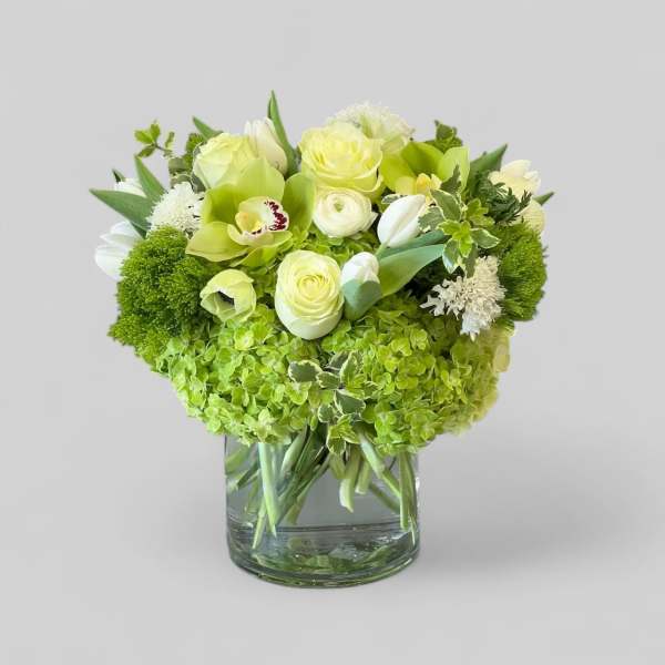 Green and white bouquet in a clear glass vase