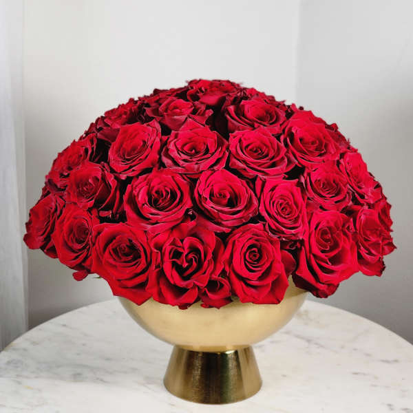 Round bouquet of red roses in a gold vase