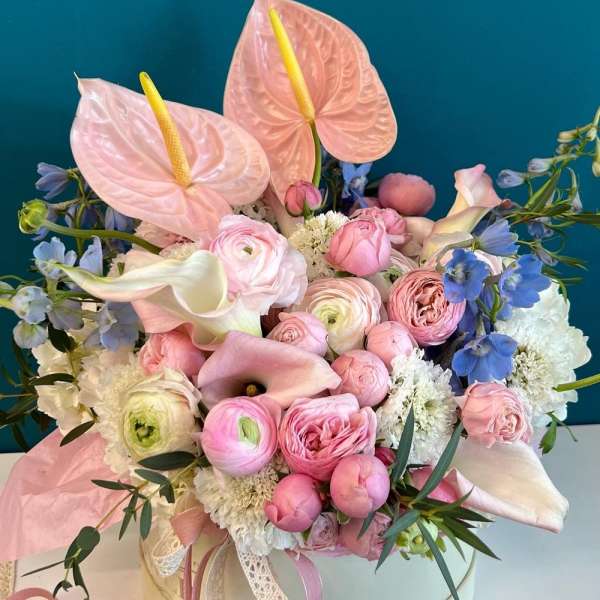 Pink and white bouquet with anthuriums, roses, and calla lilies in a round box